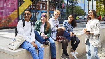 Photo of students sat outside MC Building