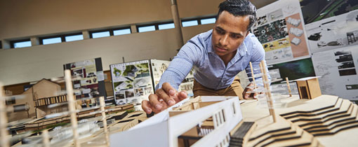 Student working with scale model of buildings