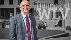 Geoff Layer standing in front of a monochrome backdrop of the Lord Swraj Paul building