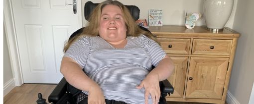 Alumni Ceri Davies sitting in wheelchair smiling at camera
