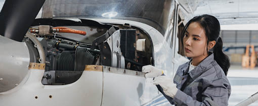 Student working on a plane engine inside a workshop