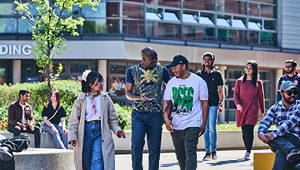 Students walking on campus in the sunshine