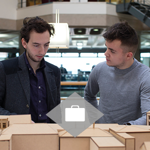 Students looking over a model of a building