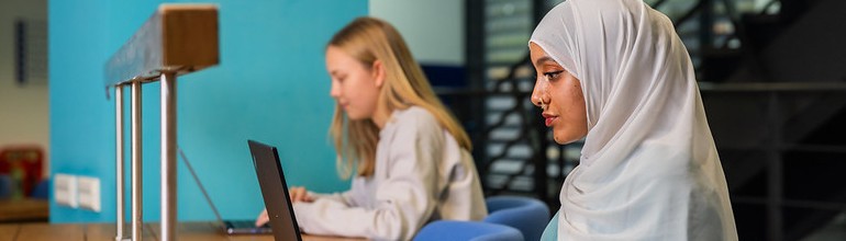 Students working on laptops in the library